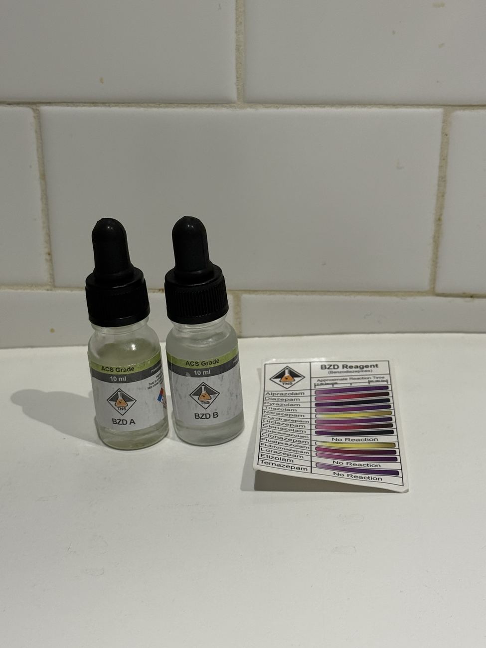 BZD A and BZD B benzodiazepine reagent bottles beside a color chart listing alprazolam, diazepam, etizolam and other benzodiazepines