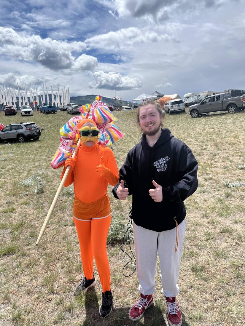 Two people giving a thumbs up at an outdoor community event